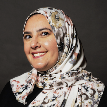 Person smiling in a flowery white hijab